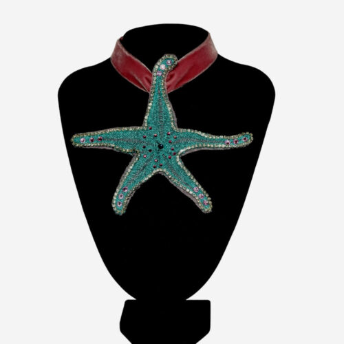 Colgante Estrella de Mar de encaje azul, una joya artesanal única hecha a mano por Josefina Campaña. Diseño elegante y exclusivo que combina la tradición gallega con un toque moderno, perfecto para realzar tu estilo con distinción.