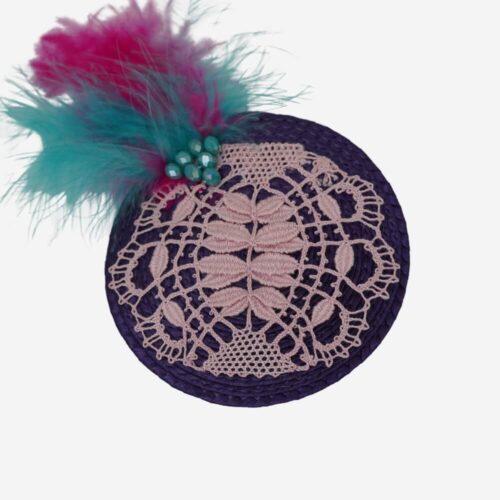 Tocado lila con aplicación de encaje de Camariñas, hecho a mano por la diseñadora Josefina Campaña. Accesorio único que combina la suavidad del encaje con un toque elegante y sofisticado, ideal para complementar tu look con un estilo exclusivo y lleno de encanto.